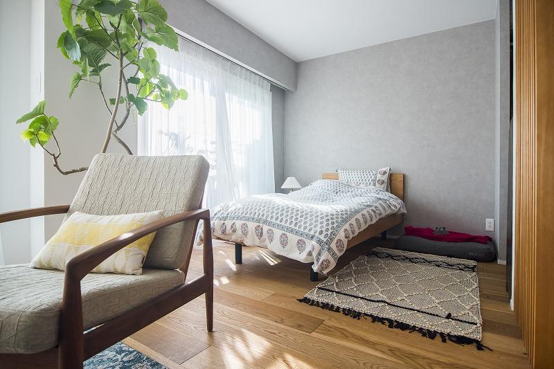 壁や扉で区切るのではなく、異なる素材の壁や格子で空間分け！
壁は、リビング側が白の漆喰で、寝室側をグレーの壁紙に。お部屋を広く、開放的な空間に見せるこだわりポイントです。