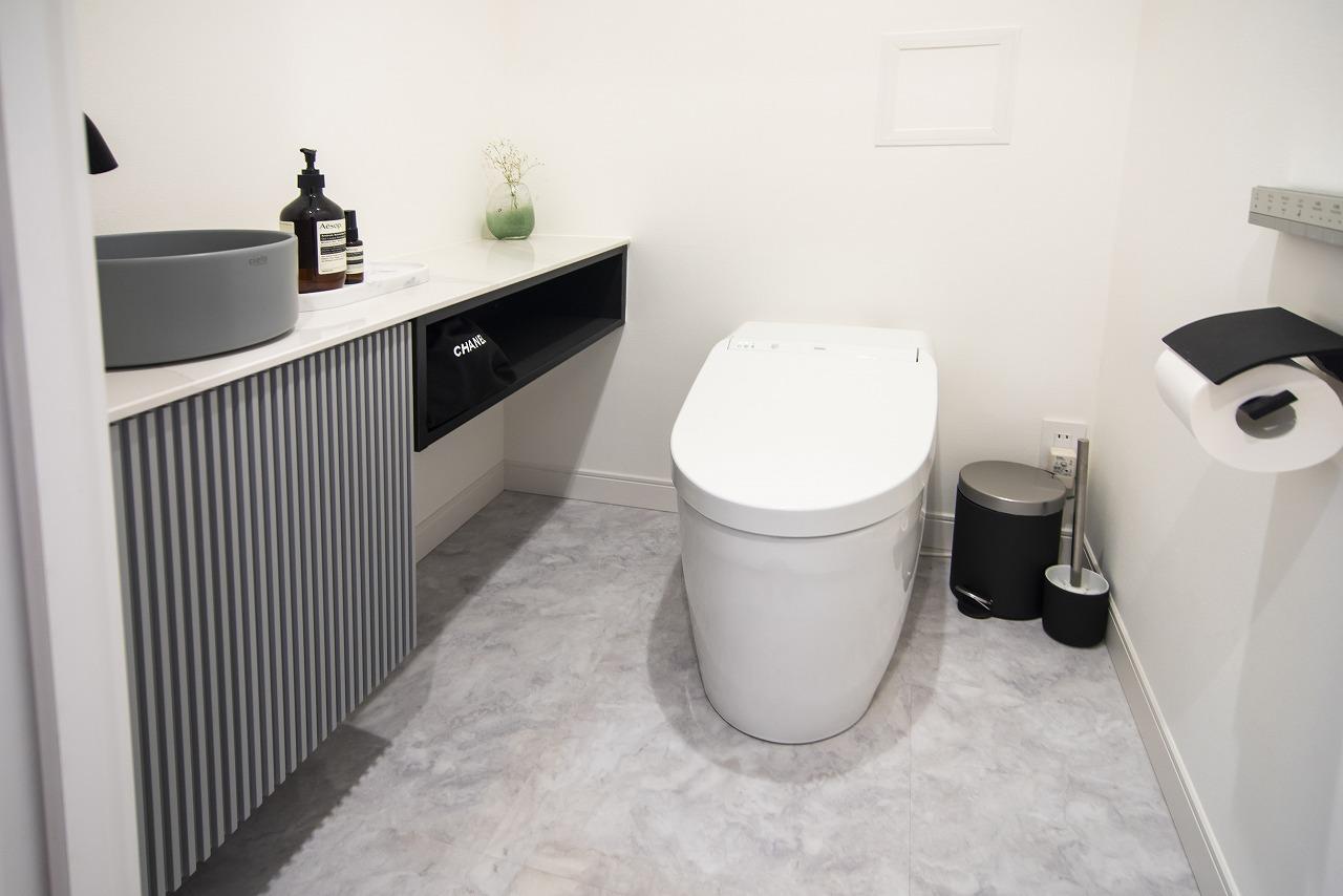 【レストルーム】
洗練されたお部屋にぴったりのタンクレストイレです。グレーの手洗いボウルやインテリアを楽しめるカウンターをオーダーで設けました。