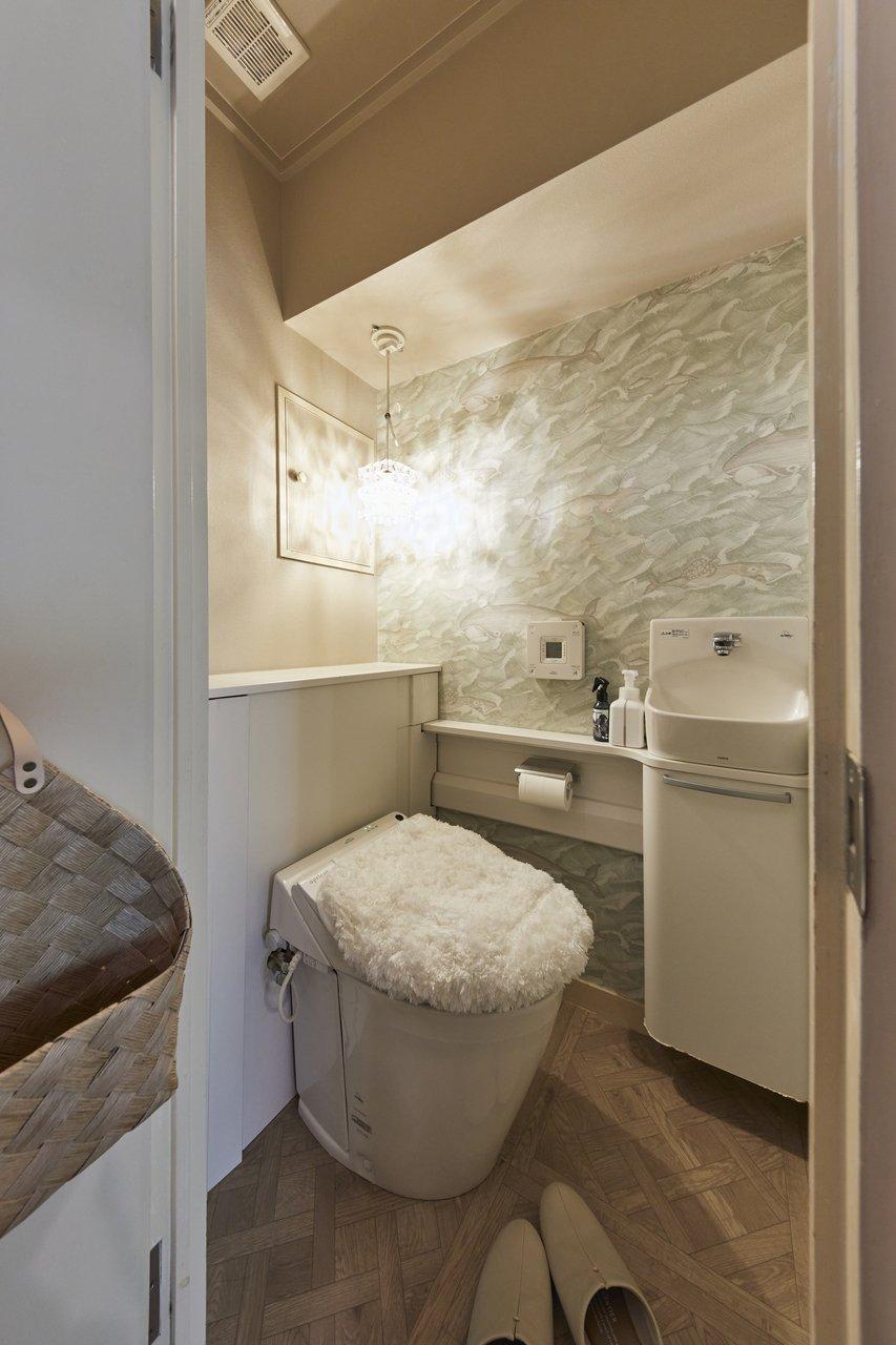 どうしても使いたかったという海外製の壁紙を採用し、照明にもこだわったトイレ。