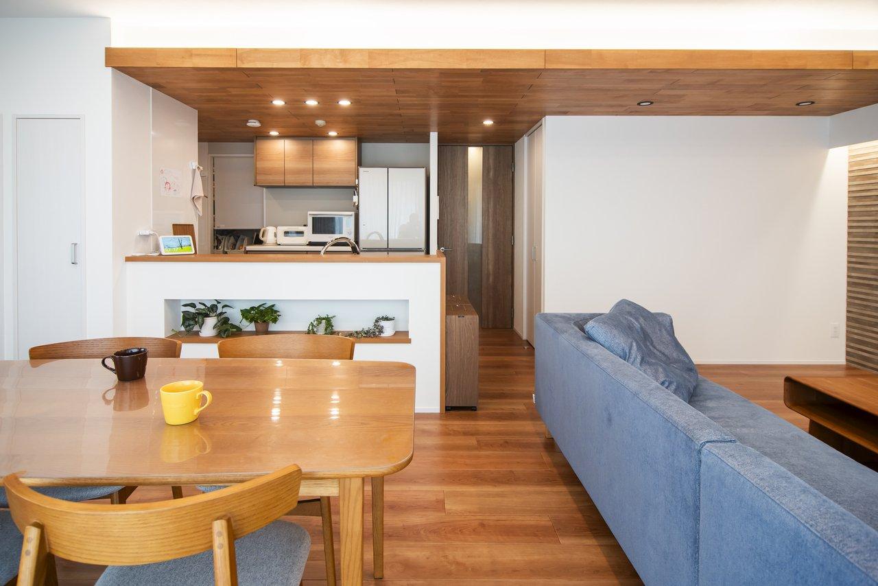 天井は、梁を活用して床の色と調和する無垢材を貼り、間接照明を取り付けました。