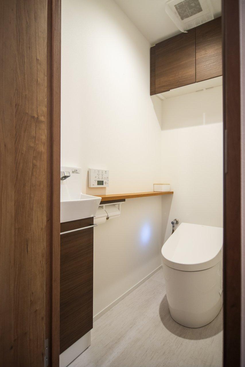 トイレには、ペーパー収納に便利な吊戸棚と手洗いカウンターを新設しました。