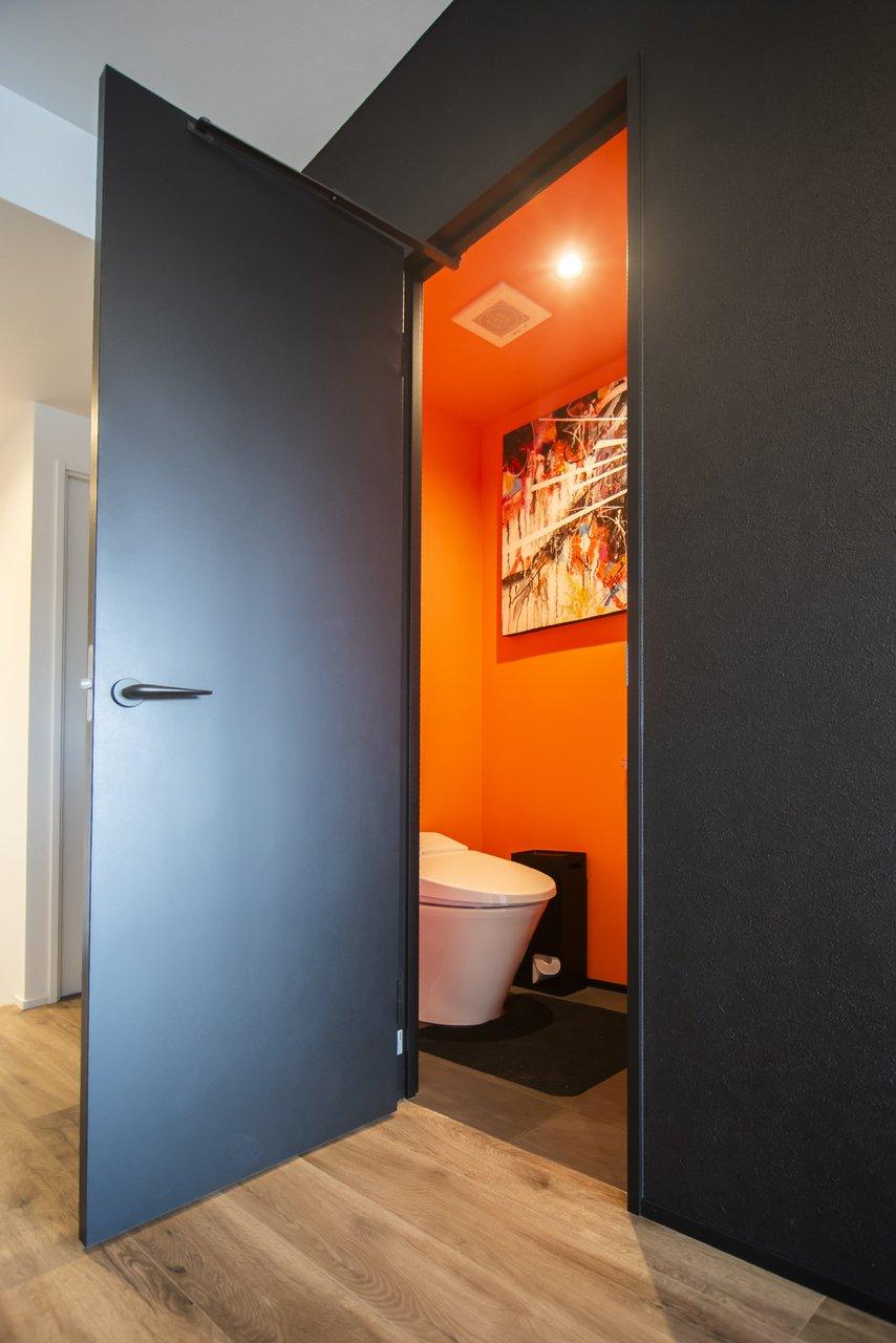 オレンジの壁紙を採用したトイレ。