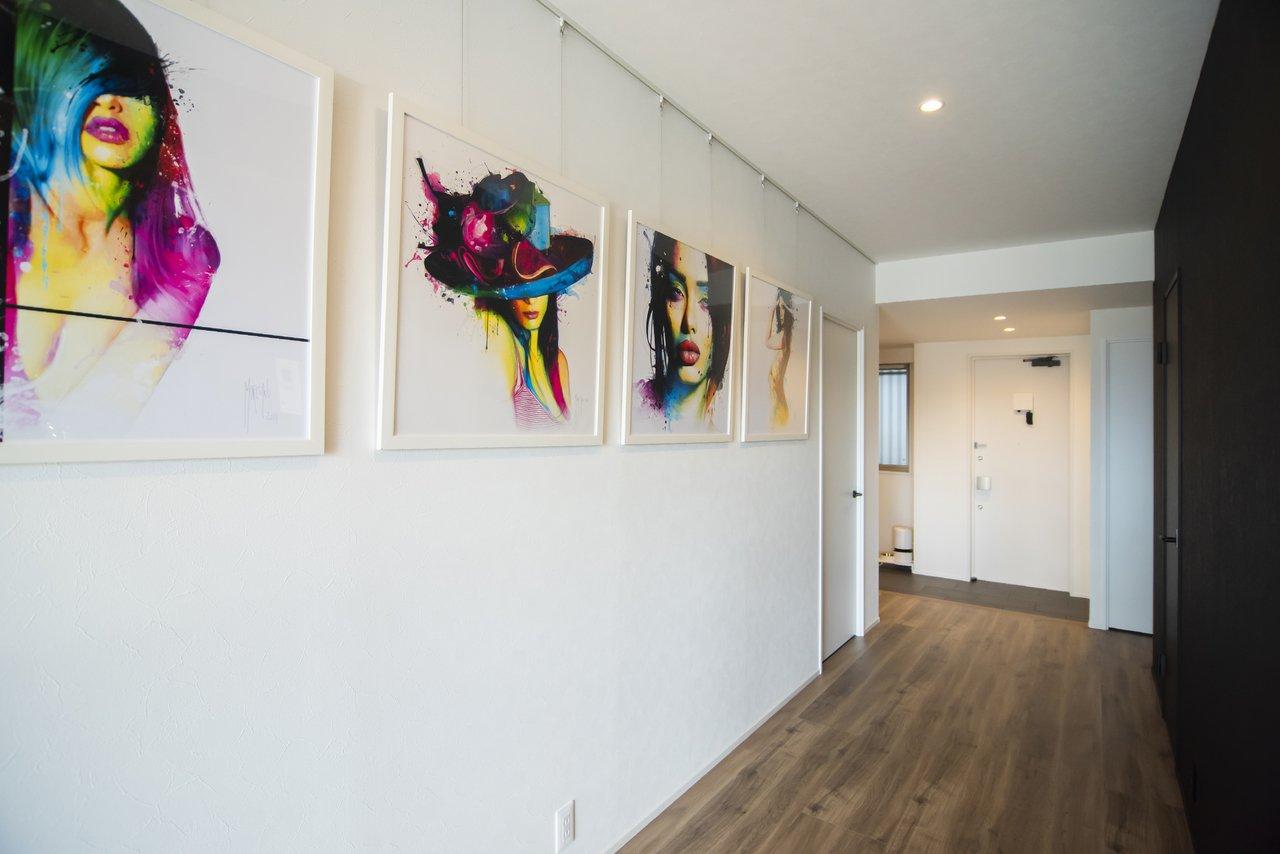 玄関ホールから廊下までピクチャーレールを設置し、お部屋の中にアートギャラリーのような空間をつくりました。