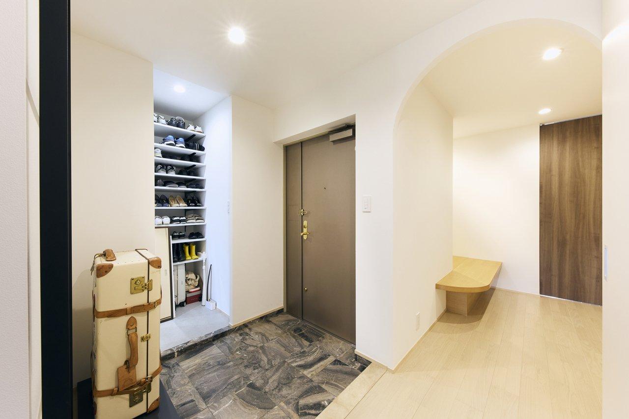玄関は、床の大理石を既存利用。もともと設置されていたシューズボックスを取り払い、踏込床を造作しました。現在はキャリーケースを置いていますが、将来的には植物とベンチを置きたいと考えているそう。