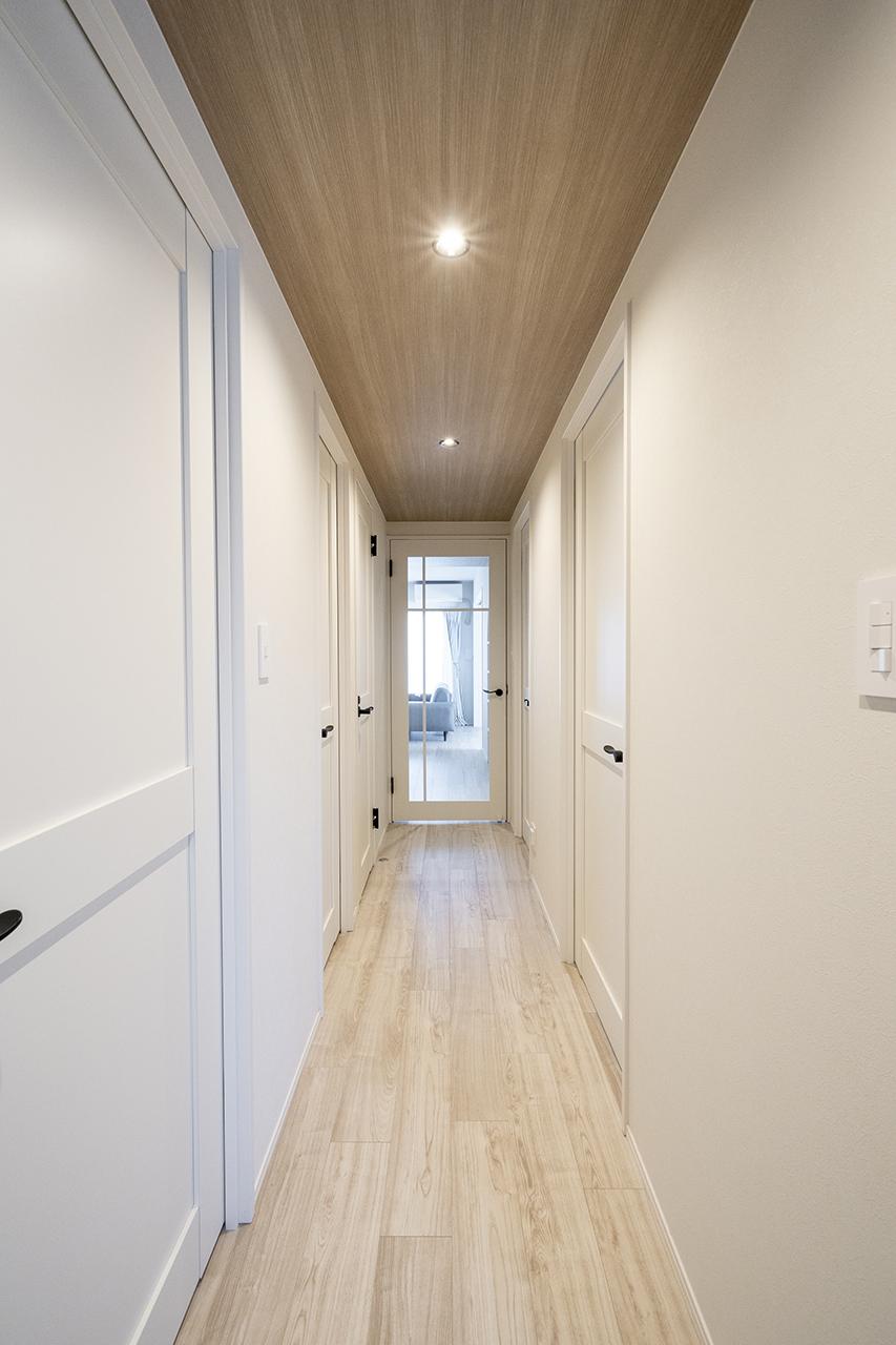 グレイッシュな木目柄のクロスを採用した廊下