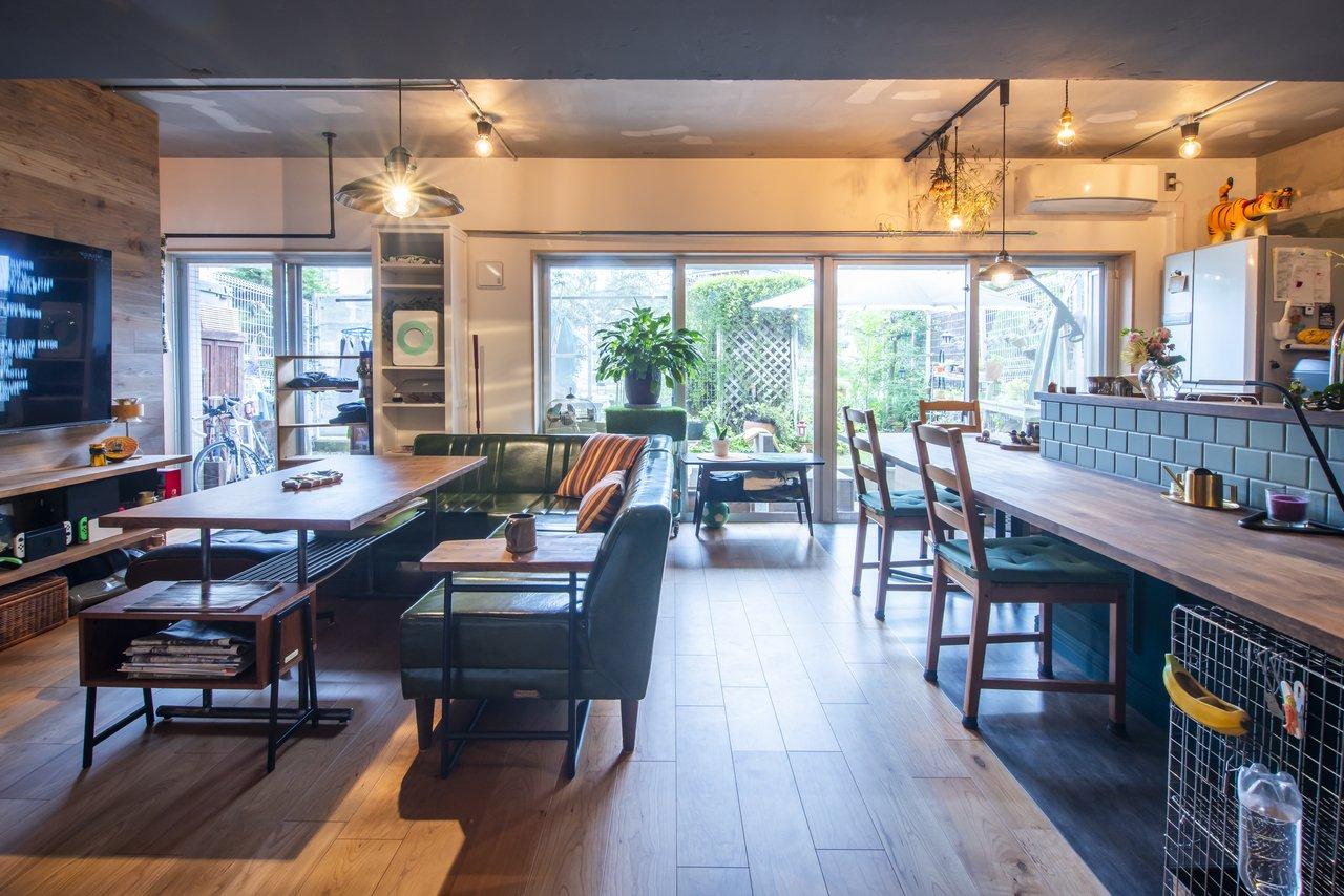 内装の緑と庭の緑が調和するLDK。庭ではバラや桜、オリーブ、バジルやミントなどの植物を育てています。