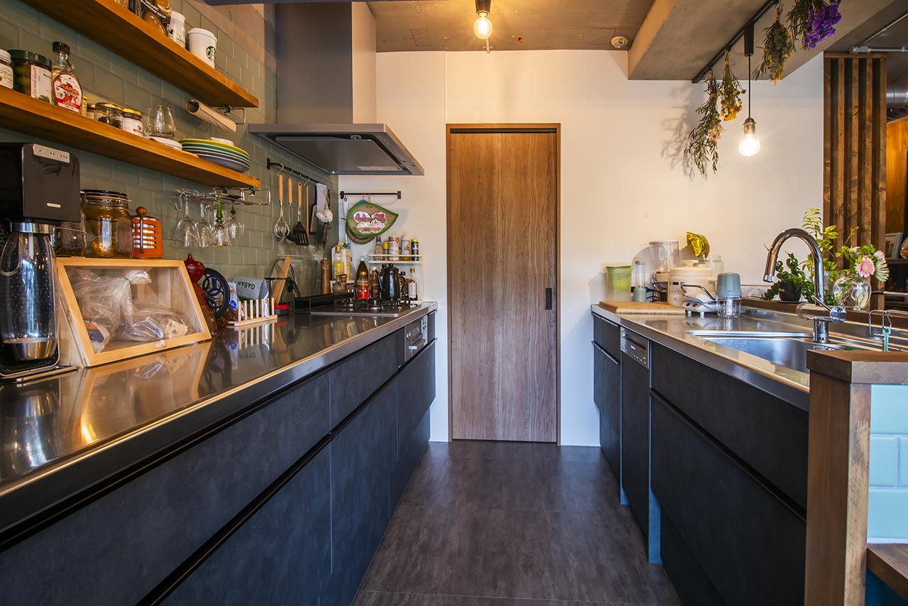 キッチンの壁面には、マットな質感の淡いグリーンのタイルを採用しました。キッチンの引き戸を開けると洗面室とつながります。