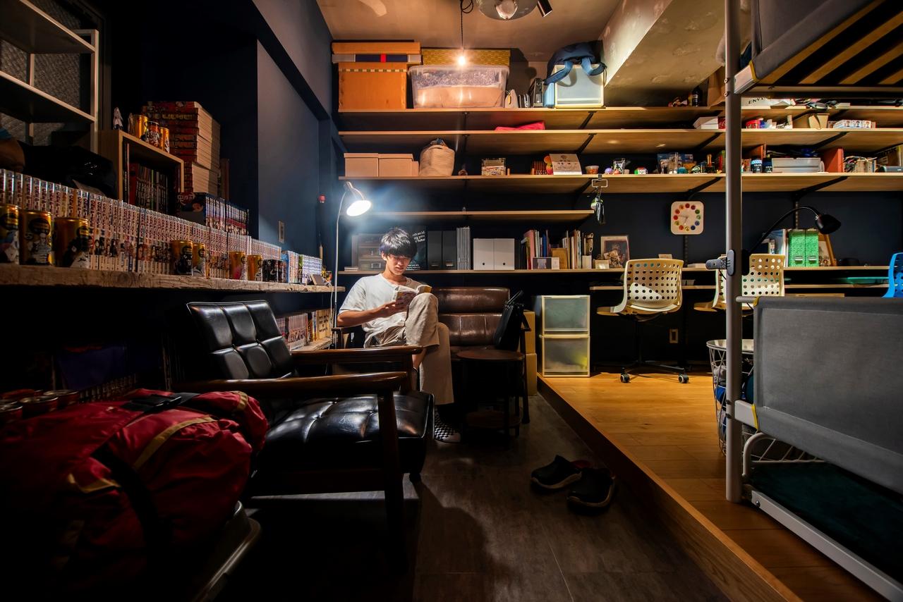 玄関を入って左の土間は、ガレージのような隠れ家スペース。窓際のカウンターには漫画がずらりと並びます。