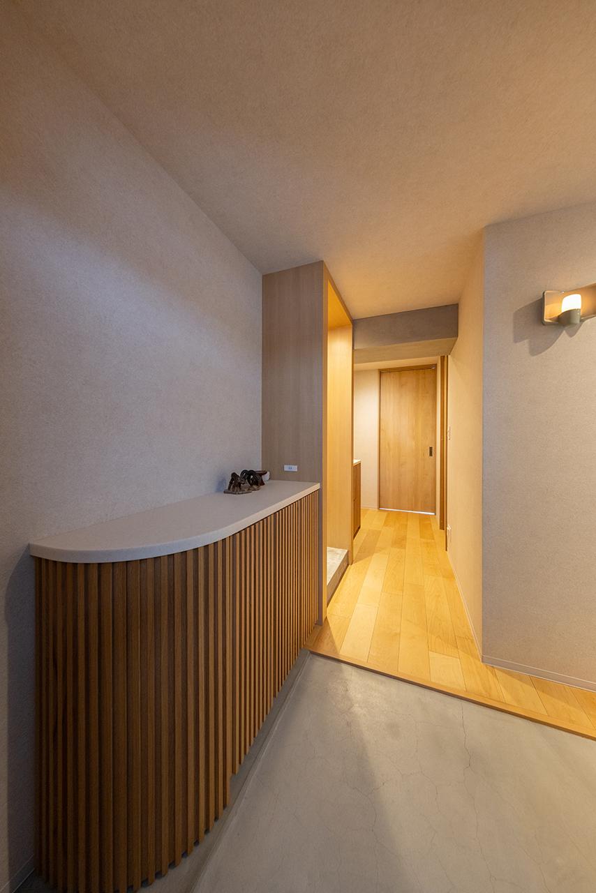 キッチンや洗面台とデザインを揃えた玄関収納がアクセントの玄関