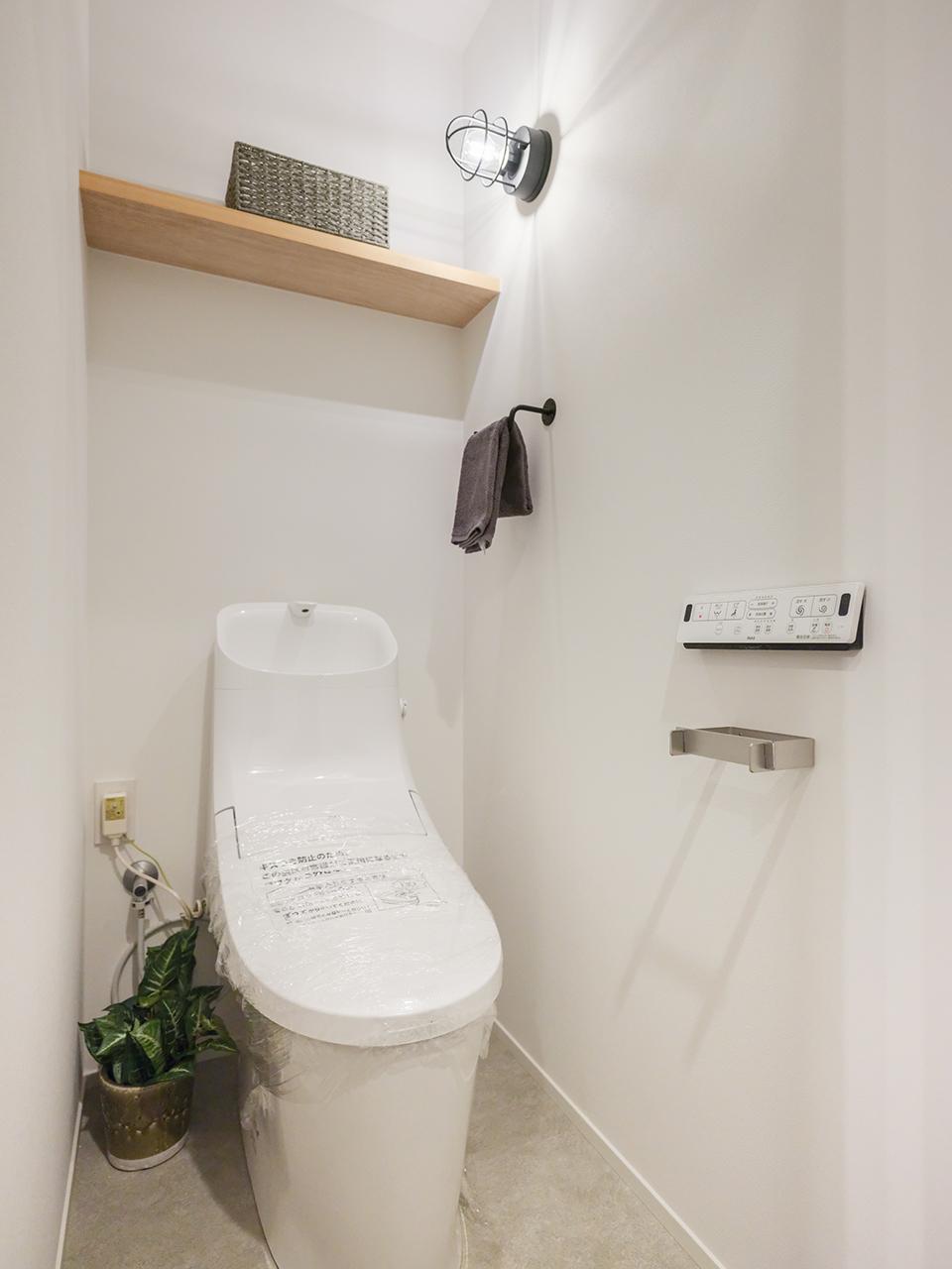 レトロな照明器具がアクセントになったシンプルなトイレ