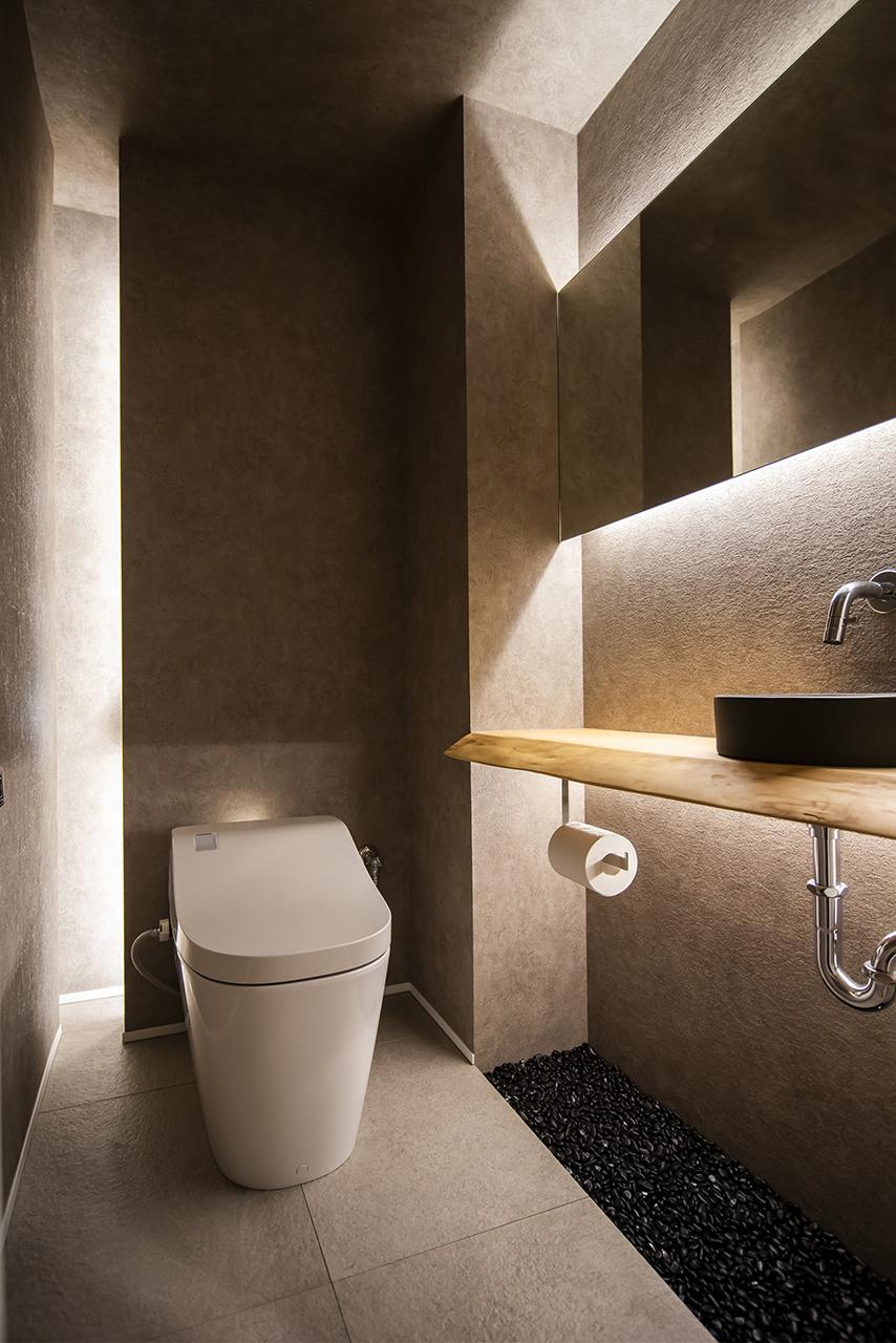 一枚板のカウンターやグレーの玉砂利を使用したトイレ