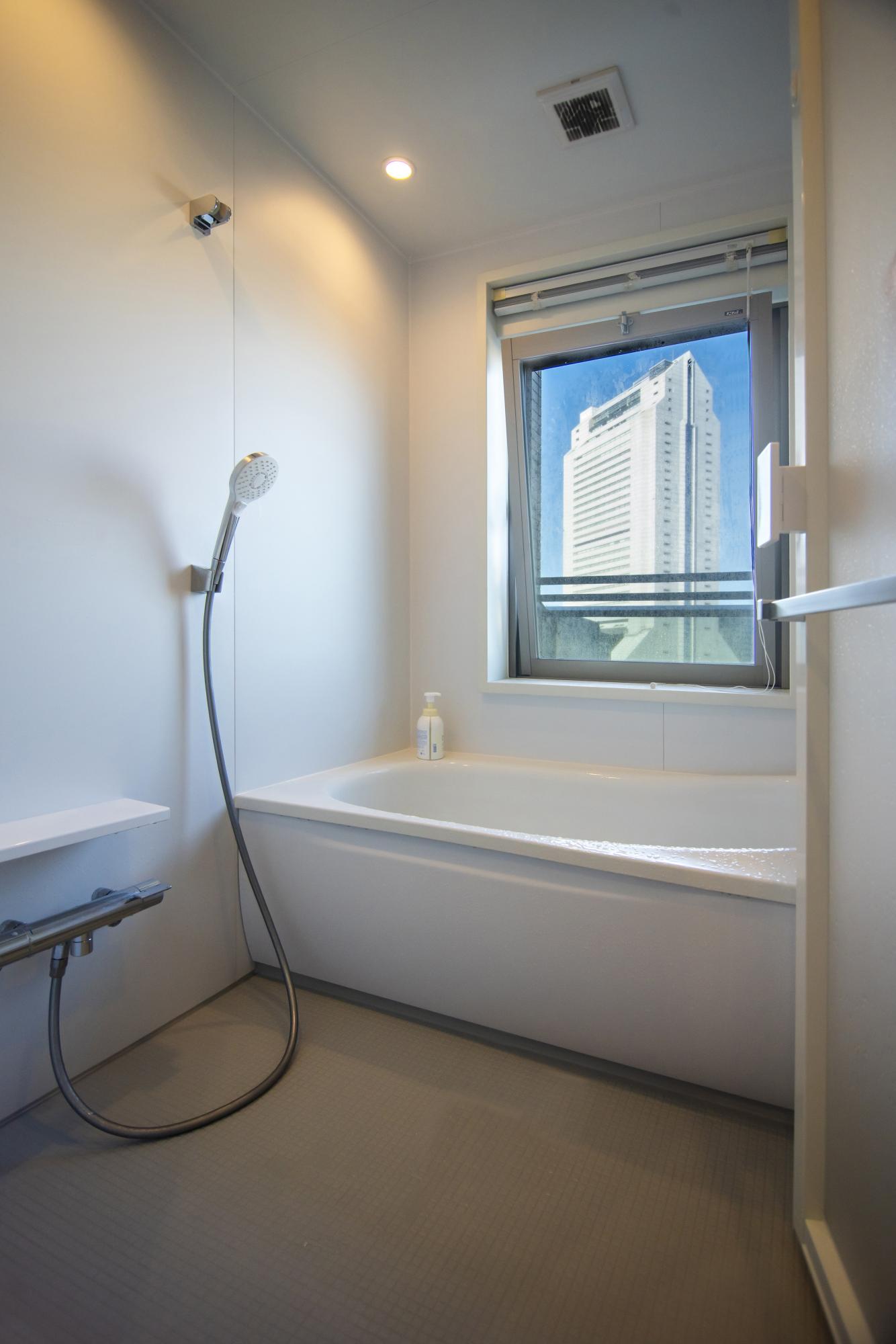 大きな窓から自然光が差し込む、開放感のある浴室。