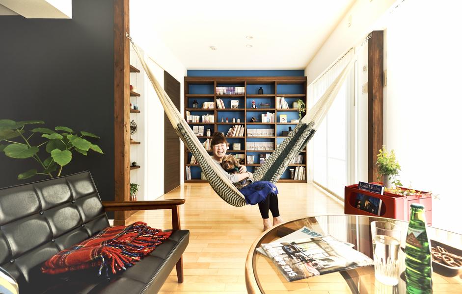 ハンモック用の付け柱を設けたリビングです。ブルーの壁や黒板塗装がアクセントになりました。壁面いっぱいの本棚はオーダーメイドです。