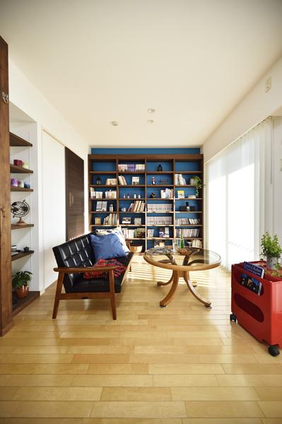 ブルーを背景にしたリビングです。奥のオープン棚で収納とインテリアを両立。マニッシュなインテリアがセンス良く調和しました。