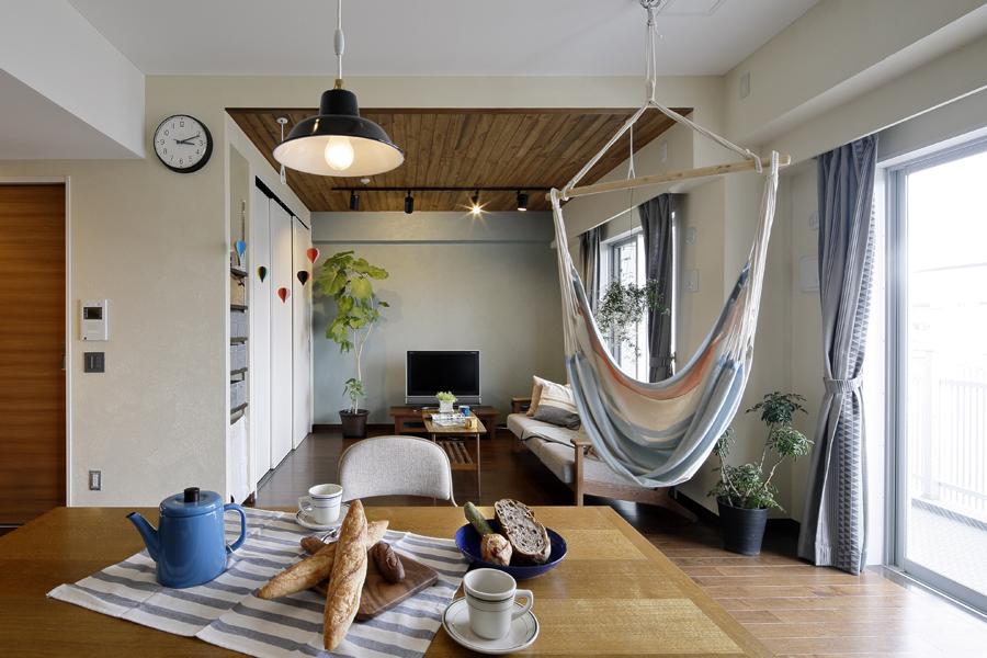 グリーンが爽やかな明るいLDです。隣室との間仕切りをなくし、大きくまとめました。珪藻土を壁に施工して調湿・消臭効果をプラス。リビング天井は羽目板造りでナチュラルな雰囲気です。ハンモックハンガーも設置して遊び心も加わりました。