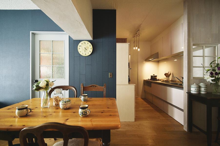 出入り口の両サイドを板張りした優雅なキッチンです。右手の愛らしい内窓で閉塞感もなく明るさも確保。下がり壁には珪藻土でザックリと塗り跡をつけ独特の趣きです。