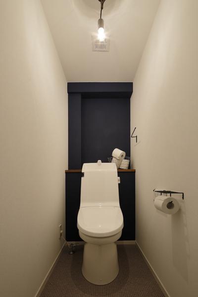 最奥だけダークブルーに塗装したトイレです。周囲はホワイト色。配色効果でより奥行き深く感じます。ペーパーホルダー・タオルハンガーはアイアン造りで、照明はシンプルにむき出しの電球のみ。LDKの無骨なテイストを踏襲してスタイリッシュ。