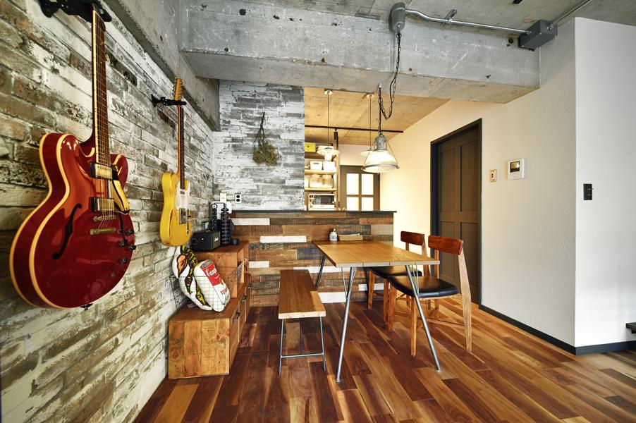 コンクリート造の梁でスタイリッシュな雰囲気のダイニングです。天井を高く上げることで空間そのものの体積を広げました。壁を使ってご愛用のギターを飾れる収納スペースをご用意しました。