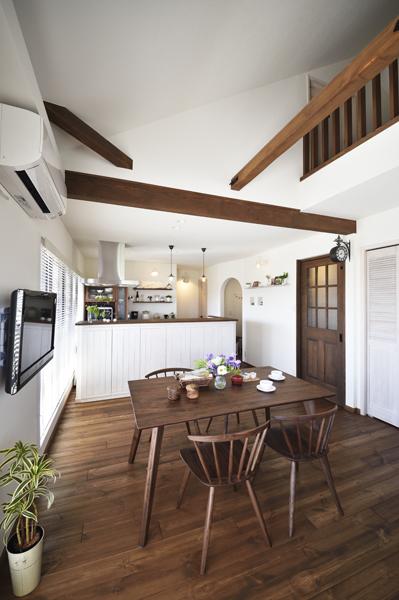 斜天井の吹き抜けを臨むダイニングです。現し梁が美しく風景に溶け込んでいます。間接照明で広がりを演出。