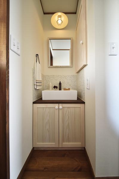 個室にせず廊下に配置した洗面コーナーです。水に強いタイルをモザイク状に装飾しました。壁面に収納を造作。