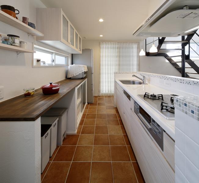 タイルにこだわった明るいキッチンです。床はブラウン調、キッチンカウンターは爽やかなモザイクタイル、キッチン腰壁は白タイルを施工しました。収納はオリジナル家具を造作