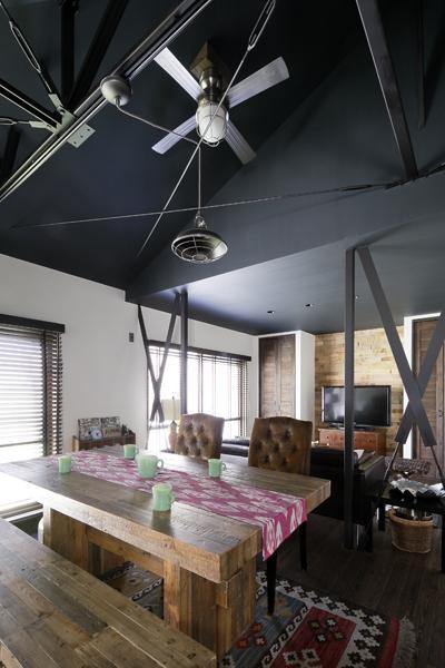 シーリングファンを設えたダイニングです。ダーク色で天井塗装しました。無骨な鉄材が頭上を横ぎり米・ダークファンタジー風。顕しの筋交いも飽きない魅力です。家具や照明も個性的です。
