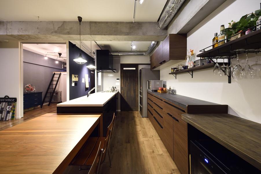 配管パイプもインテリアになるダイニング・キッチンです。手前はダイニング、コンクリートの梁の先はキッチンです。建具やスクリーンは濃色にして「個室」のような囲まれ感を演出。