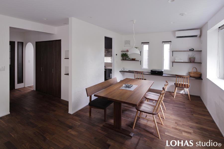 漆喰の壁で大空間を住み分けた個室風のダイニングです。奥には無垢パイン材でワークカウンターを造作。天井には耐久性のある石目調のエコクロスを施工しています。