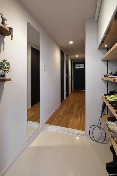 パイン材で可動タイプの収納棚を造作した玄関です。靴収納はロールスクリーンでスッキリと目隠しできるよう工夫しました。室内の床はチーク無垢材です。