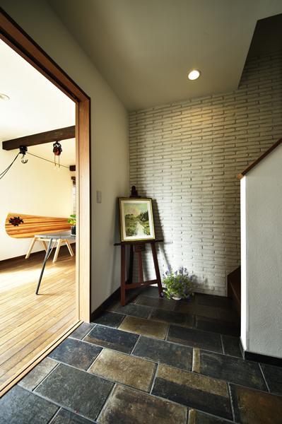 色むらが味わい深い 輸入タイルを施工した廊下です。耐震性確保で造作した耐力壁に白いアクセントタイルを装飾しました。(正面)