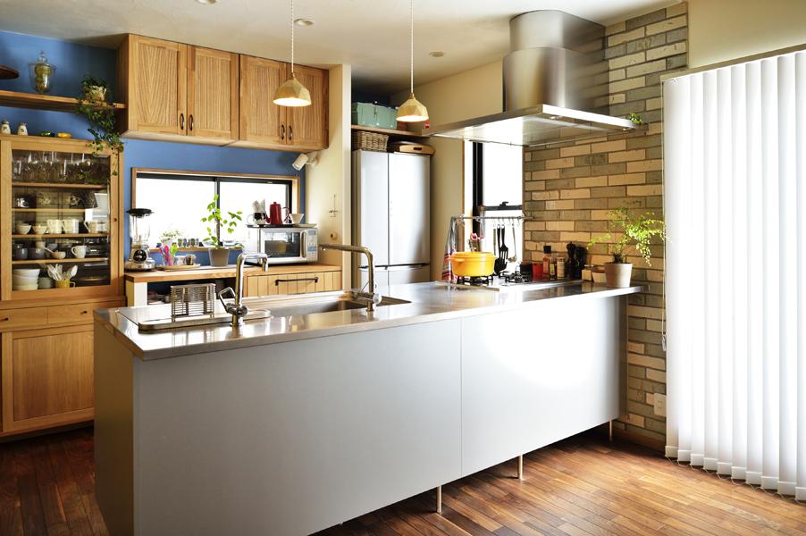 ステンレス製品を備えた対面式キッチンです。背面はクラシカルな青トーンで優しい雰囲気。吊り戸棚のないオープンタイプなのでお子さまの様子がひと目で分かります。