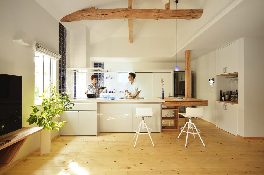 北欧的なバイカラーの優美なキッチンです。ご要望で通路を広めにしたゆとりある設計。ダイニングテーブルを造作して調理台とフラットにつなげました。背面は大容量の「見せない」大型収納を造作しています。