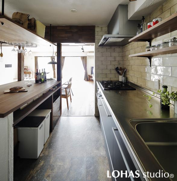 ご夫妻のこだわりを反映した使いやすいキッチンです。「熱がこもるので風を入れたい」けれど「風でコンロの火が消える」のジレンマをレイアウト変更で解消しました。壁で方向を変えた風が室内に涼感を届けてくれます。