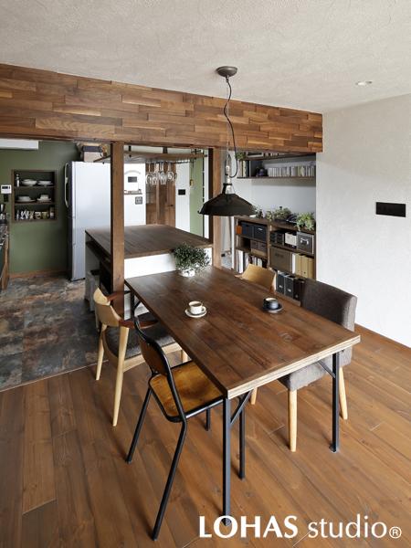キッチンカウンターと隣り合うシンプルなダイニングです。木を乱張りした下がり壁がカフェスタイルでお洒落。同系統で異なる色を織り交ぜた飽きのこないビジュアルです。シンプルな黒いペンダントライトがアクセントになりました。
