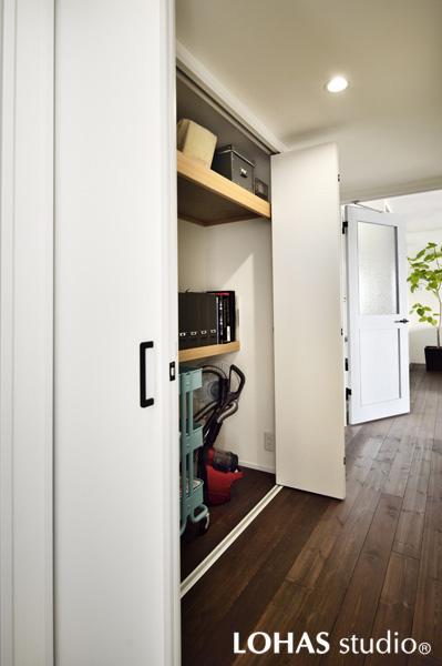 廊下にご用意した折り戸タイプの収納です。開閉スペースが比較的小さく通路を塞ぐ心配がありません。中に造作した棚は高低に合わせて奥行を変えました。掃除機などの家電がすっぽり入ります。