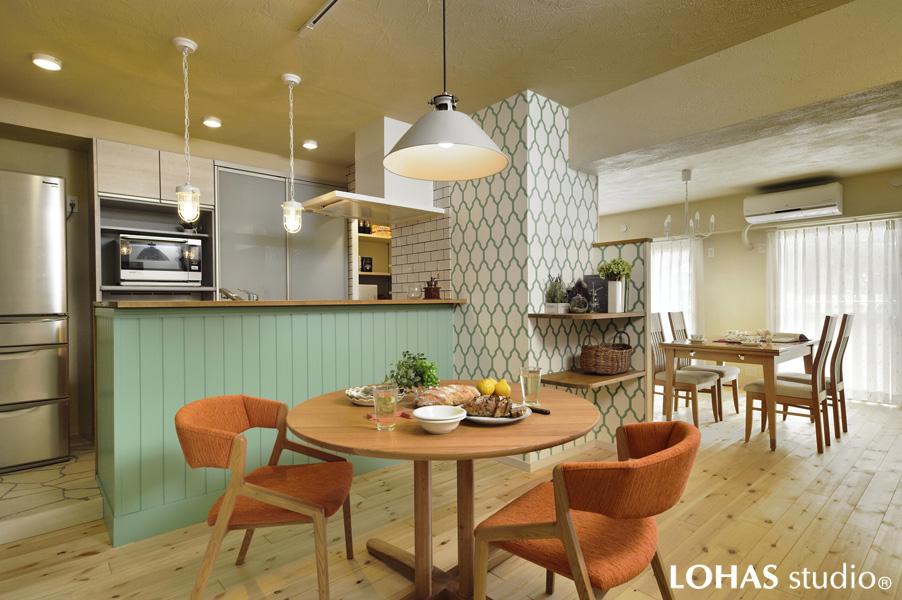 色や柄が素敵に調和した温もりあるLDKです。フローリングは明るい木肌の無垢パイン材。壁や天井は珪藻土をメインにアクセントクロスを採り入れました。カウンターのグリーン色は邸内のキーカラー、羽目板がお洒落です。