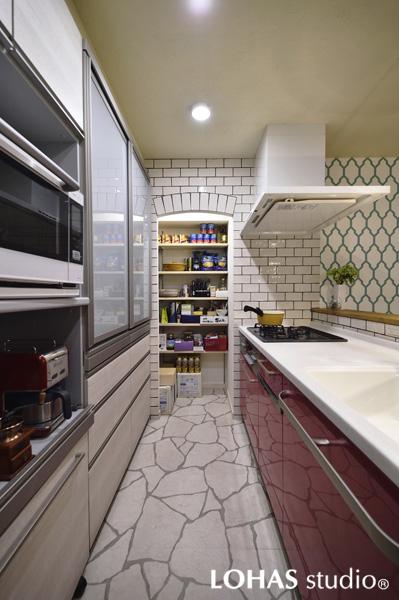 リゾートをイメージしてデザインした対面キッチンです。挿し色のピンク色は奥様の好リクエスト。石調のフロアタイルや艶のあるタイルで上品な質感に仕上がっています。パントリーや収納棚で室内はスッキリ！