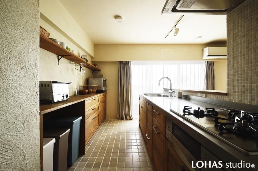 木・石素材で自然な風合いのキッチンです。天然石タイルの床が独特の素材感。壁はオリジナル色の珪藻土です。パントリー・収納・建具はオリジナルの造作家具です。