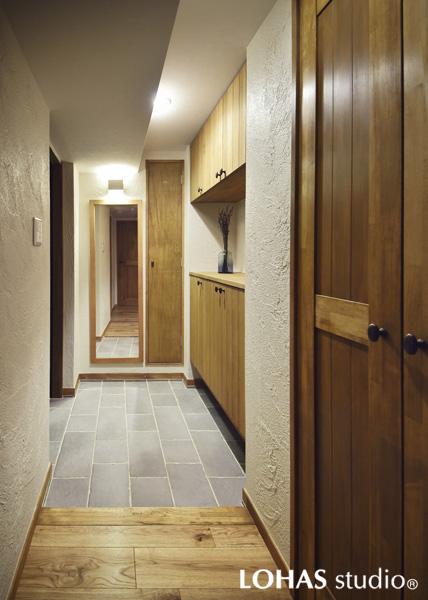 自然素材で優しい印象の玄関です。不規則なエッジの床タイルをフレンチスタイルで施工。壁に付けた珪藻土の塗り跡が素敵です。収納はナチュラルオーク色、取っ手もお揃いに。