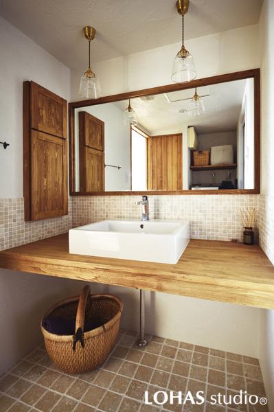 ナチュラルカントリー調の洗面室です。水栓・ボウル・照明…どれもお気に入りの1点を厳選、表情のある足元は天然割石です。建具や収納扉はパイン材で造作しました。