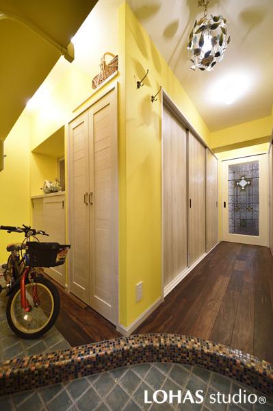 気分が上向く明るい色の玄関です。流線フォルムの框にはモザイクタイルを施工。自転車のある左手は框の高さに揃えた土間スペース。たっぷり入る収納も造作しました。