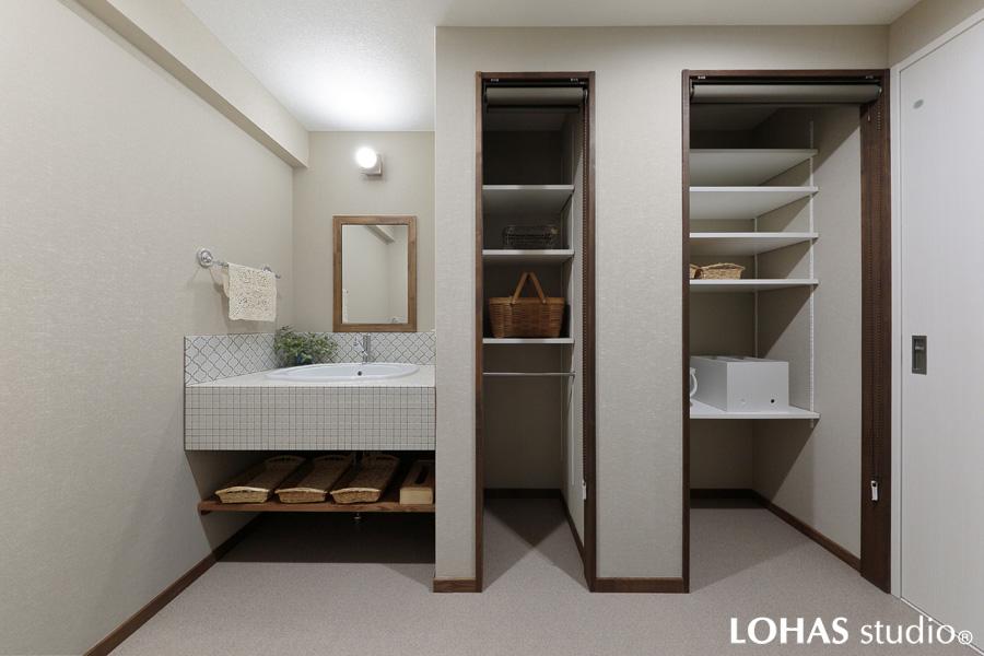 スッキリとした景観の洗面室です。モザイクタイルで飾った洗面台で上質感ある清潔な雰囲気に。足元の棚は奥行があり見た目以上の収納力です。ロールカーテンを設置したオープン棚は来客時には即座に目隠しができて便利。