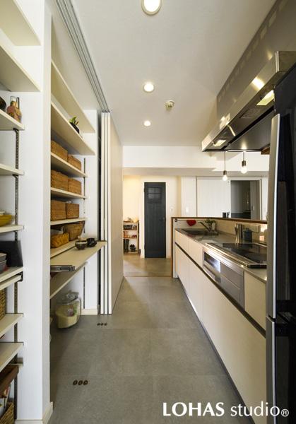 キッチンの収納スペースです。通路をふさぐ心配のない引き戸タイプで フロアはいつもスッキリ！回遊動線で出入りも楽々です。天井・壁は明るいホワイト色に調えました。床はメンテナンス性の良いフロアタイルを採用。