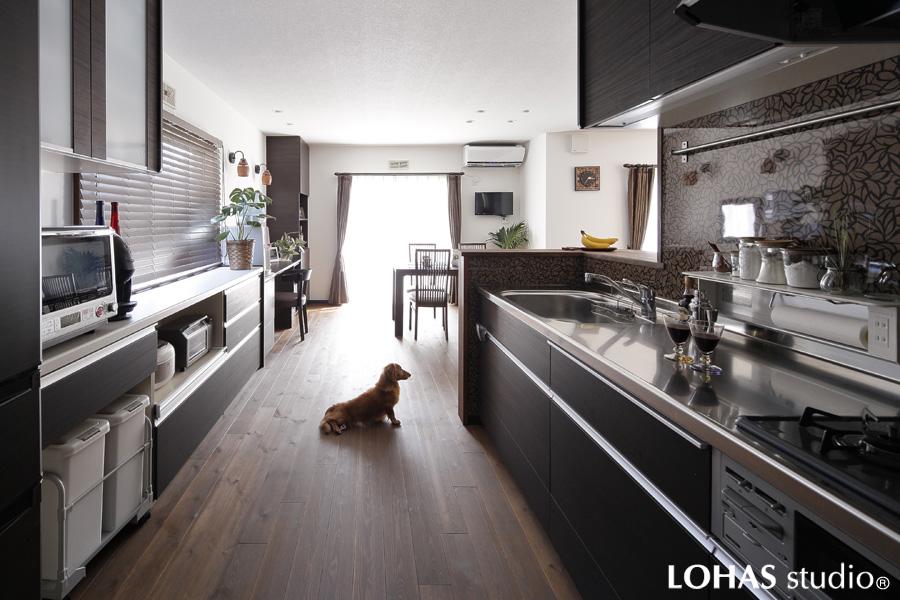 ゆったりした通路と便利な収納を具えた家事効率性の高いキッチンです。引き戸を開けた隣室の先は洗面室・浴室へ。ホテルのように使いやすい工夫をあちらこちらに盛り込みました。