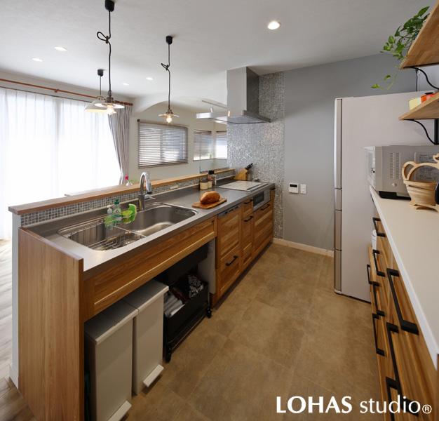 グレイッシュカラーを採り入れ洗練された雰囲気のキッチンです。透明感のあるタイルに温かな木素材を馴染ませました。ゆったりとしたLDを眺める対面型で子育てにも活躍！