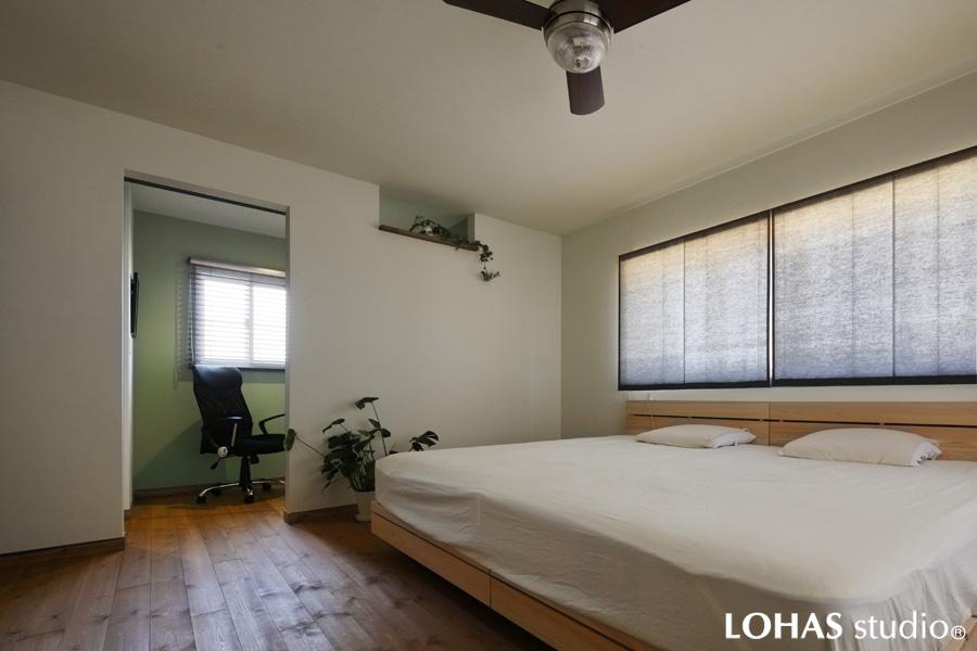 書斎を具えた2階寝室です。床は踏み心地の柔らかい無垢パイン材。壁・床は1階と同じ素材の淡グレーに揃えています。個室にはグリーンの壁色でアクセントを。