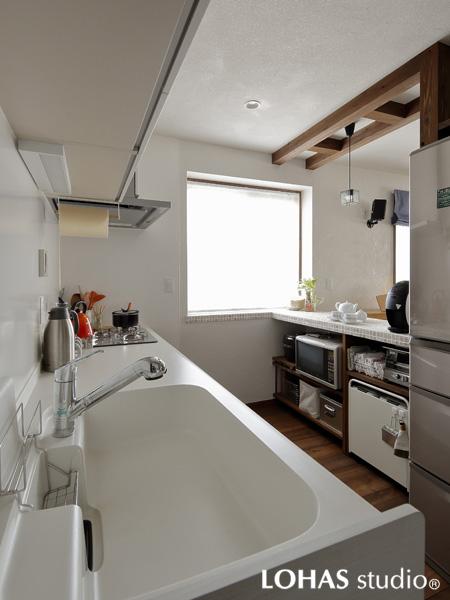 白を基調にした調度よい囲まれ感のキッチンです。家電サイズに合わせて造作したカウンター収納で室内はスッキリ。同じタイル素材で出窓とカウンターを一体的にデザインしました。カウンターは配膳台に大活躍。