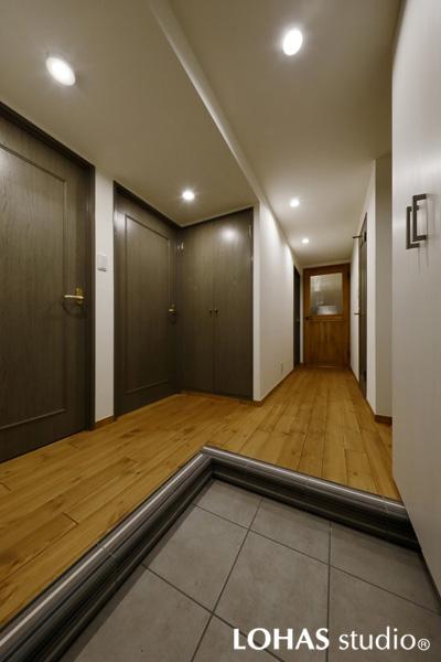 ゆとりあるアプローチの玄関ホールです。幅員の狭い団地タイプの小間がハイエンドなスペースに激変。框に施工したボーダー柄タイルが空間をマニッシュに引締めます。