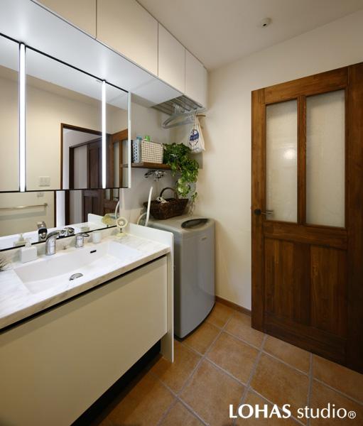 リッチな手焼き風タイルを床施工した清潔感ある洗面室です。天吊り収納を室内に合わせて横長に設置しました。一部はハンガーパイプ内蔵で室内干しもOKです。