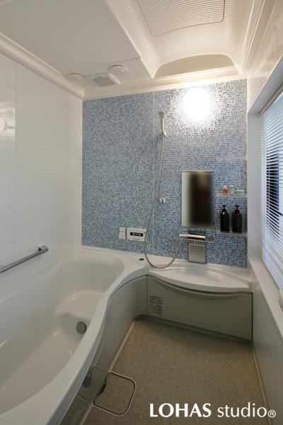 ブルーのアクセント壁が爽やかな浴室です。浴槽側には入浴の出入り時に安心な補助用の手すりを設置しました。